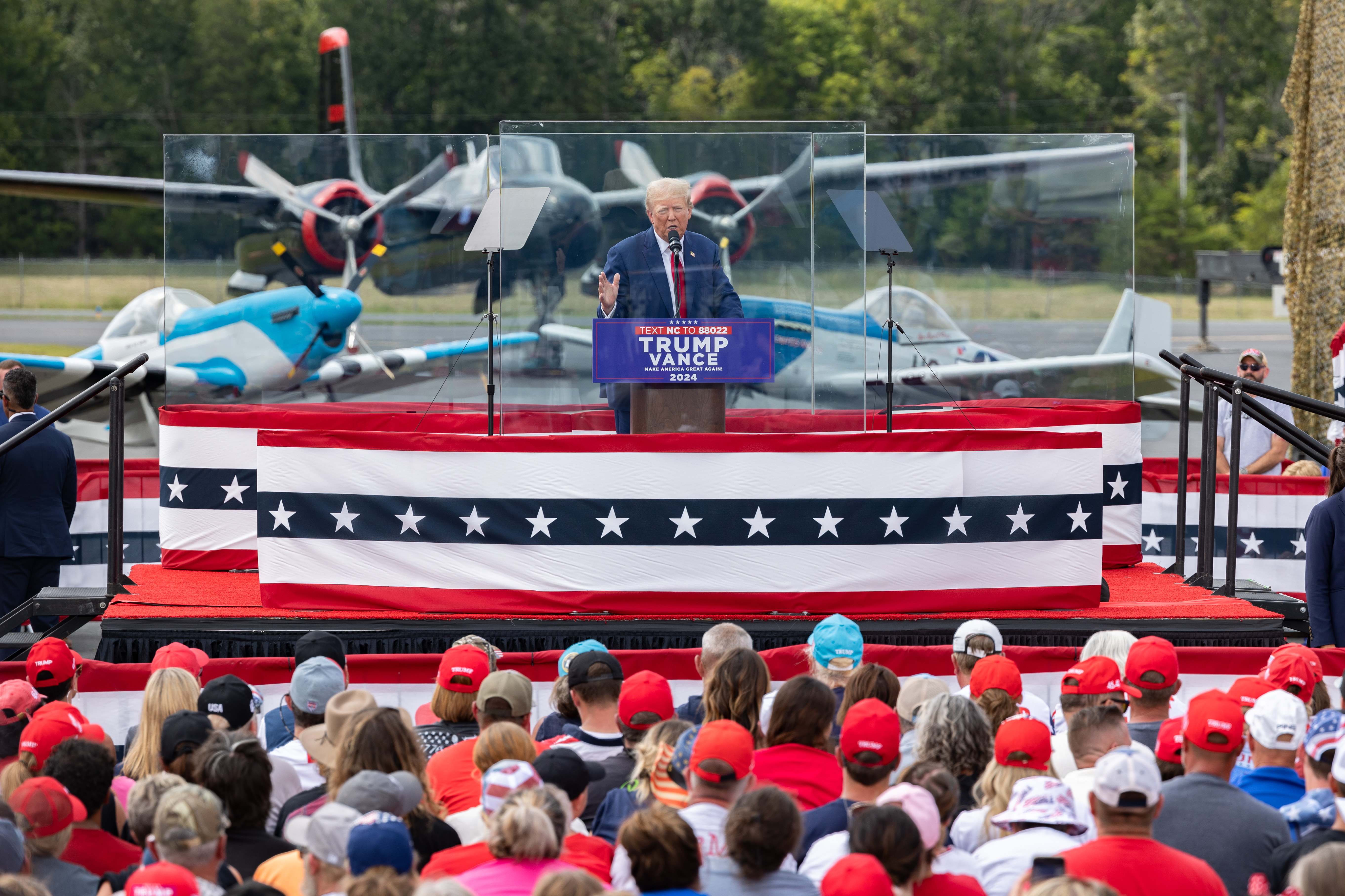 Trump behind tempered glass: Comrade Kamala will destroy America